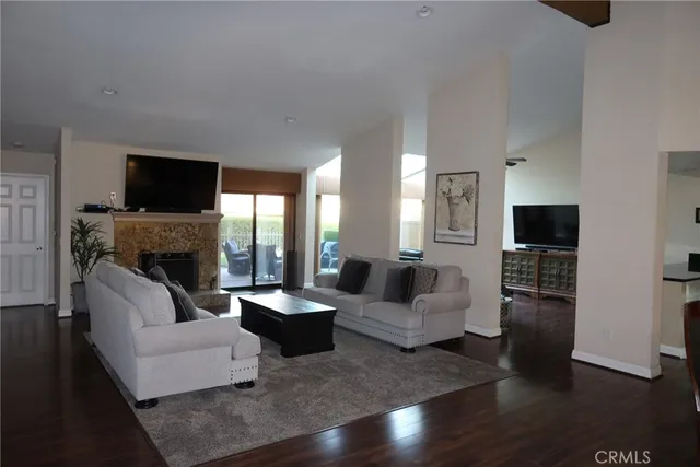 a living room with furniture a flat screen tv and a fireplace