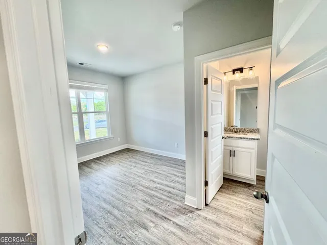 a view of a hallway with a kitchen and wooden floor