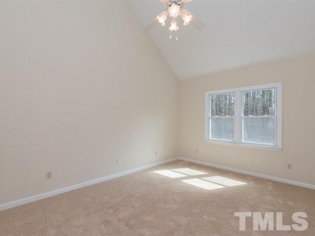 9312 Tallgrass Road Raleigh, NC 27603 - Photo 13 of 18 an empty room with a chandelier fan and windows