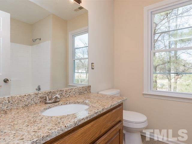 9312 Tallgrass Road Raleigh, NC 27603 - Photo 14 of 18 a bathroom with a granite countertop sink and a mirror