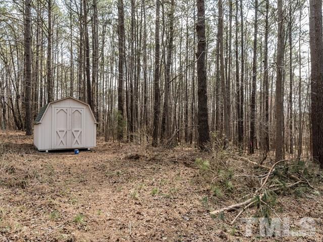 9312 Tallgrass Road Raleigh, NC 27603 - Photo 3 of 18 a view of a backyard with large trees and wooden fence