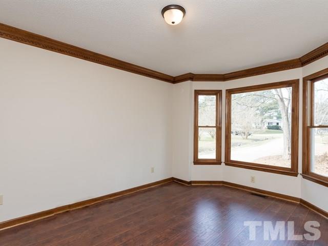 9312 Tallgrass Road Raleigh, NC 27603 - Photo 6 of 18 a view of an empty room with wooden floor and a window