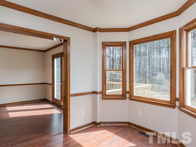 9312 Tallgrass Road Raleigh, NC 27603 - Photo 10 of 18 a view of empty room with wooden floor and fan