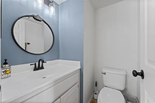 a bathroom with a sink mirror vanity and toilet