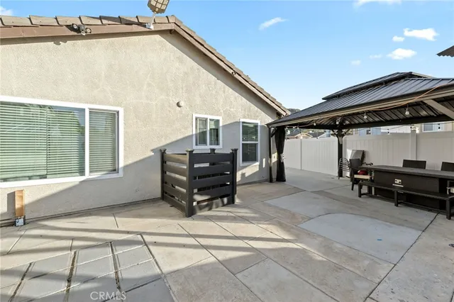 a patio with table and chairs and potted plants