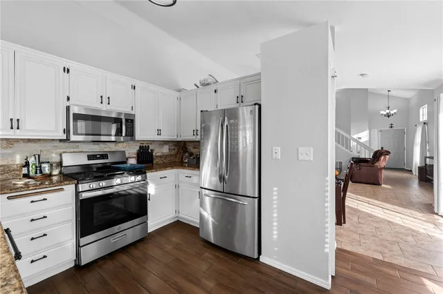 a kitchen with a refrigerator stove and white cabinets