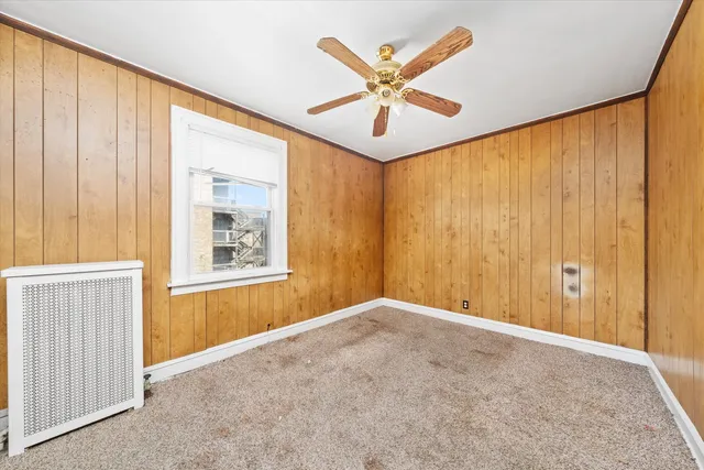 a view of a big room with windows and chandelier fan