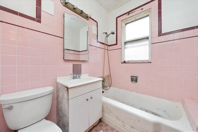 a bathroom with a sink toilet vanity and bathtub