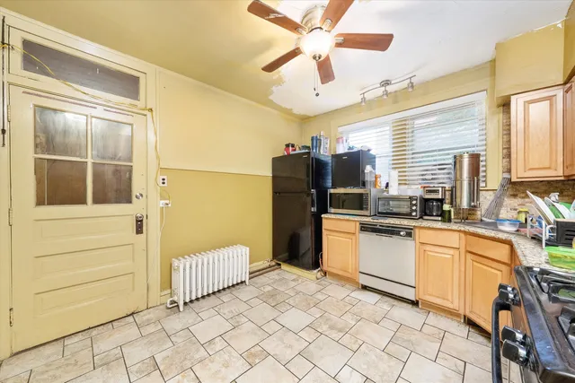 a kitchen with stainless steel appliances kitchen island granite countertop a refrigerator and a stove top oven