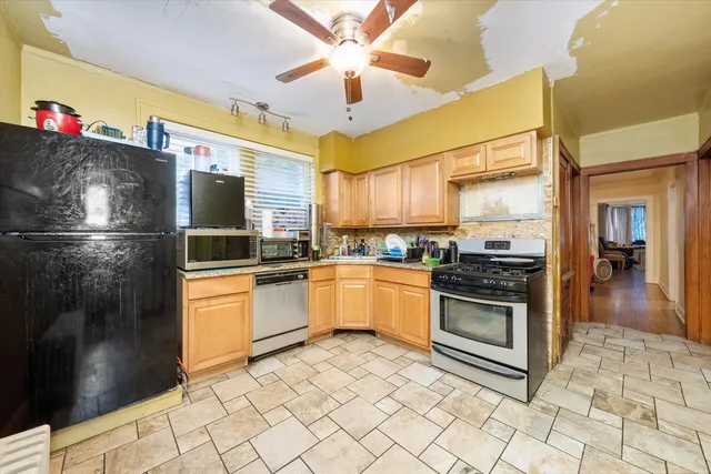 a kitchen with granite countertop a refrigerator oven a sink and dishwasher