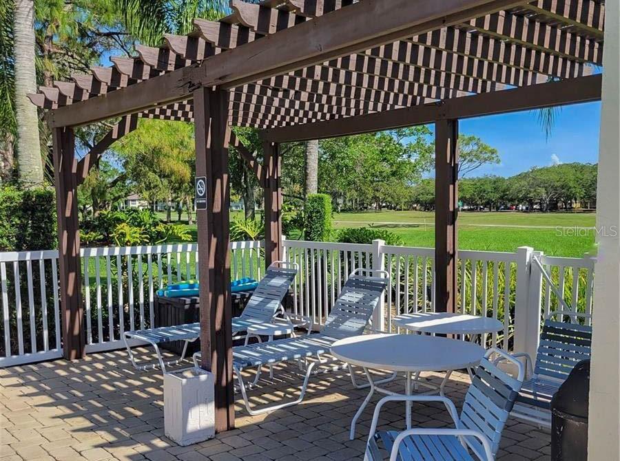 5052 Marsh Field Road, Unit 9 Sarasota, FL 34235 - Photo 15 of 15 a view of a patio with a table chairs and a porch