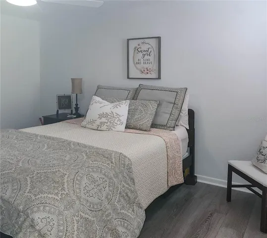 a large bed sitting in a bedroom next to a wall with wooden floor