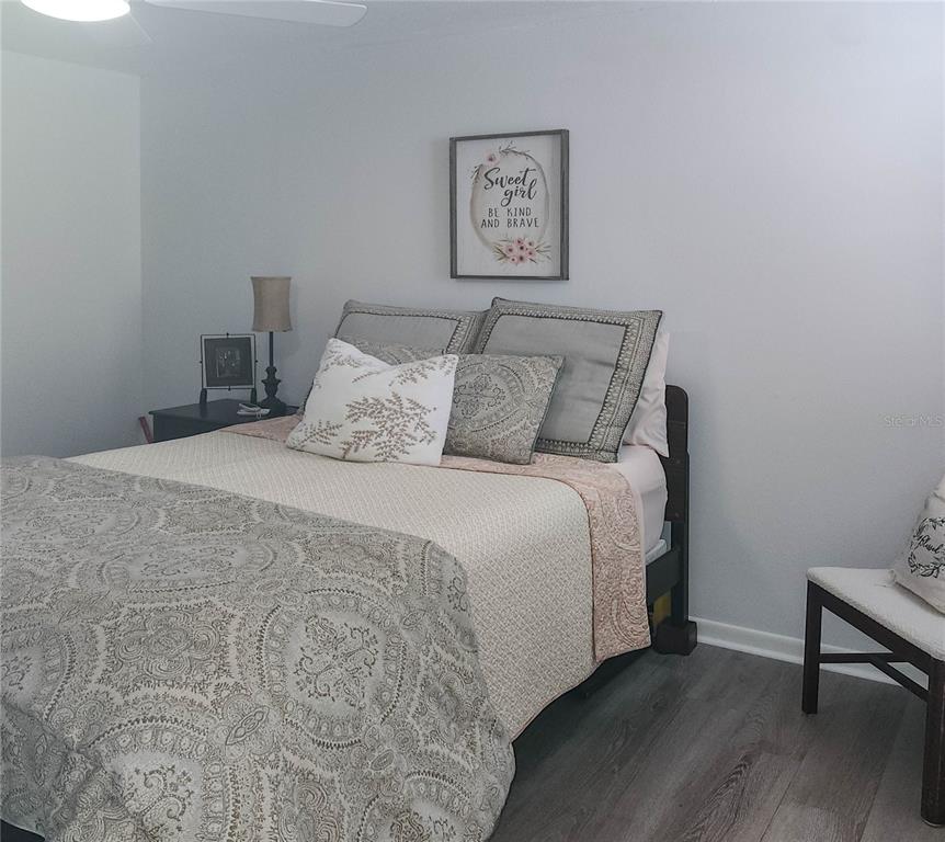 5052 Marsh Field Road, Unit 9 Sarasota, FL 34235 - Photo 7 of 15 a large bed sitting in a bedroom next to a wall with wooden floor
