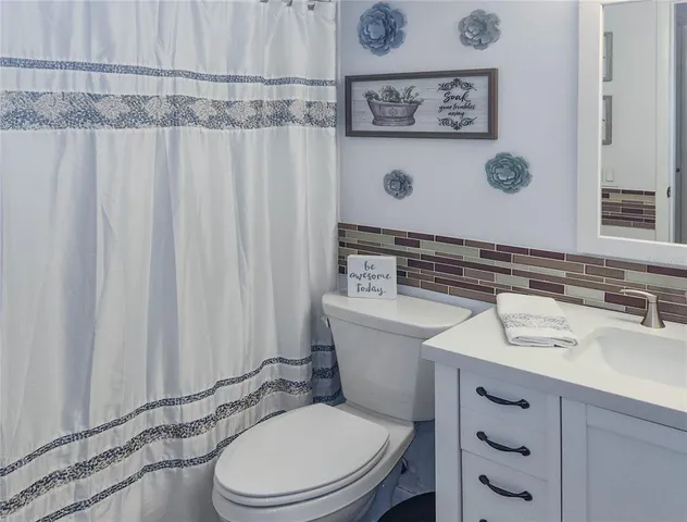 a bathroom with a sink a toilet and shower curtain