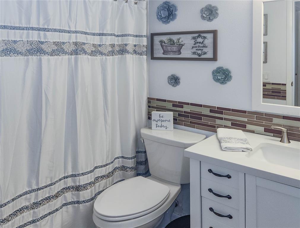 5052 Marsh Field Road, Unit 9 Sarasota, FL 34235 - Photo 8 of 15 a bathroom with a sink a toilet and shower curtain