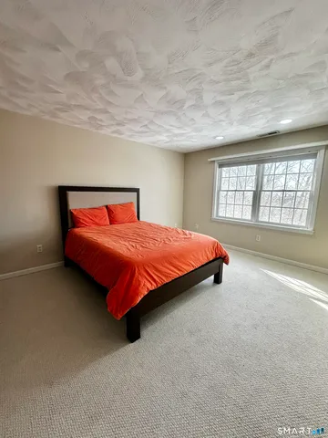 a bedroom with a bed and a large window