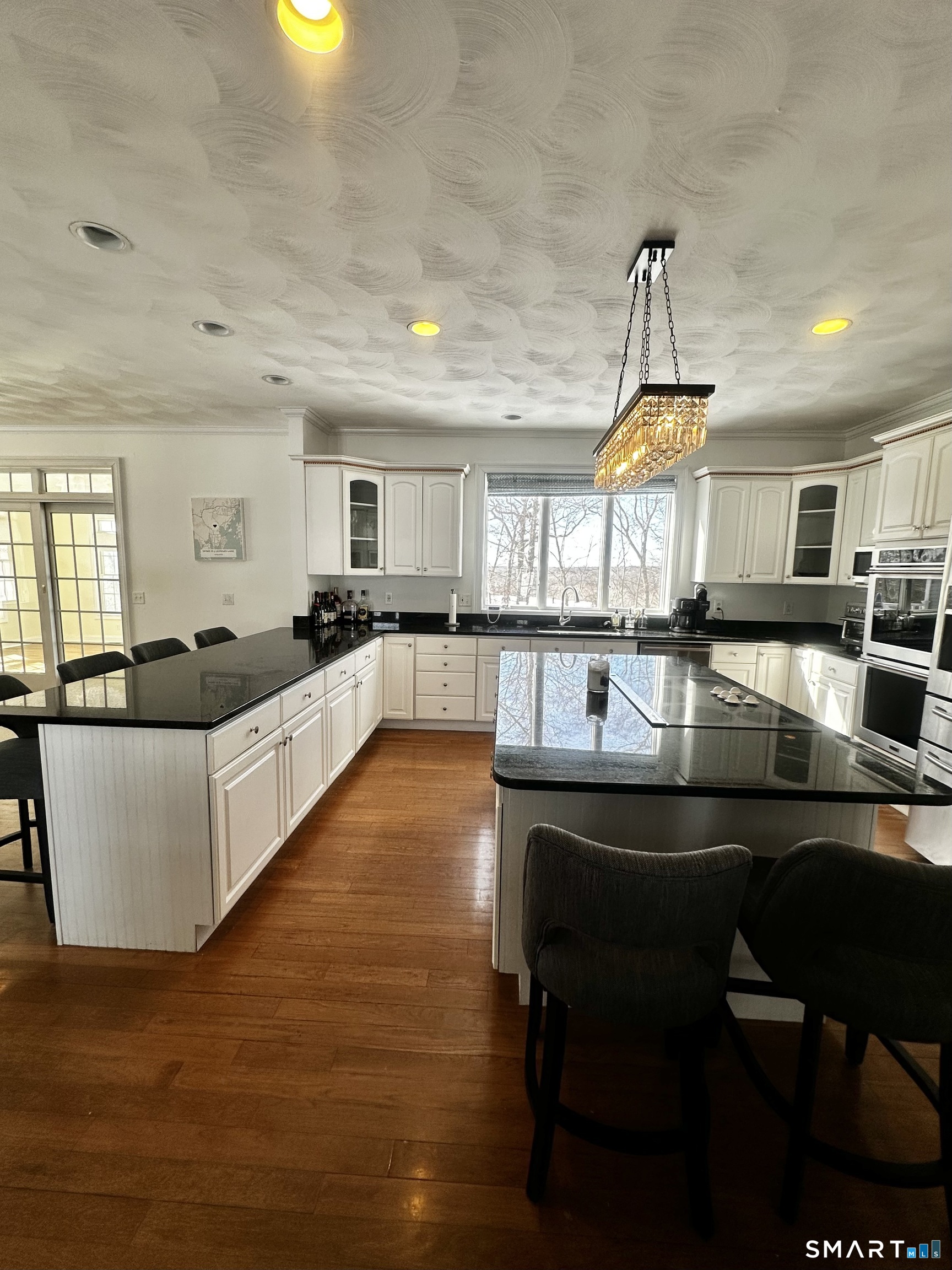 9 Leeward Lane Groton, CT 06340 - Photo 3 of 18 a kitchen with stainless steel appliances granite countertop a sink a stove top oven a dining table and chairs