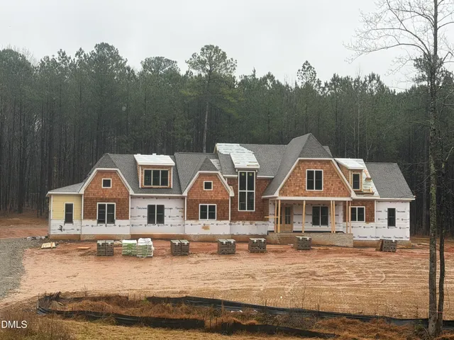 a front view of house with yard space and lake view in back