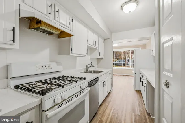 a kitchen with stainless steel appliances a sink dishwasher stove and refrigerator