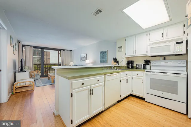 a kitchen with cabinets appliances and a wooden floor