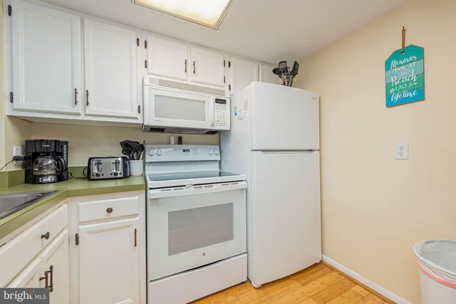 a kitchen with stainless steel appliances white cabinets and a refrigerator