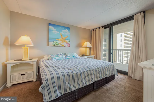 a bedroom with a bed and a lamp on dresser