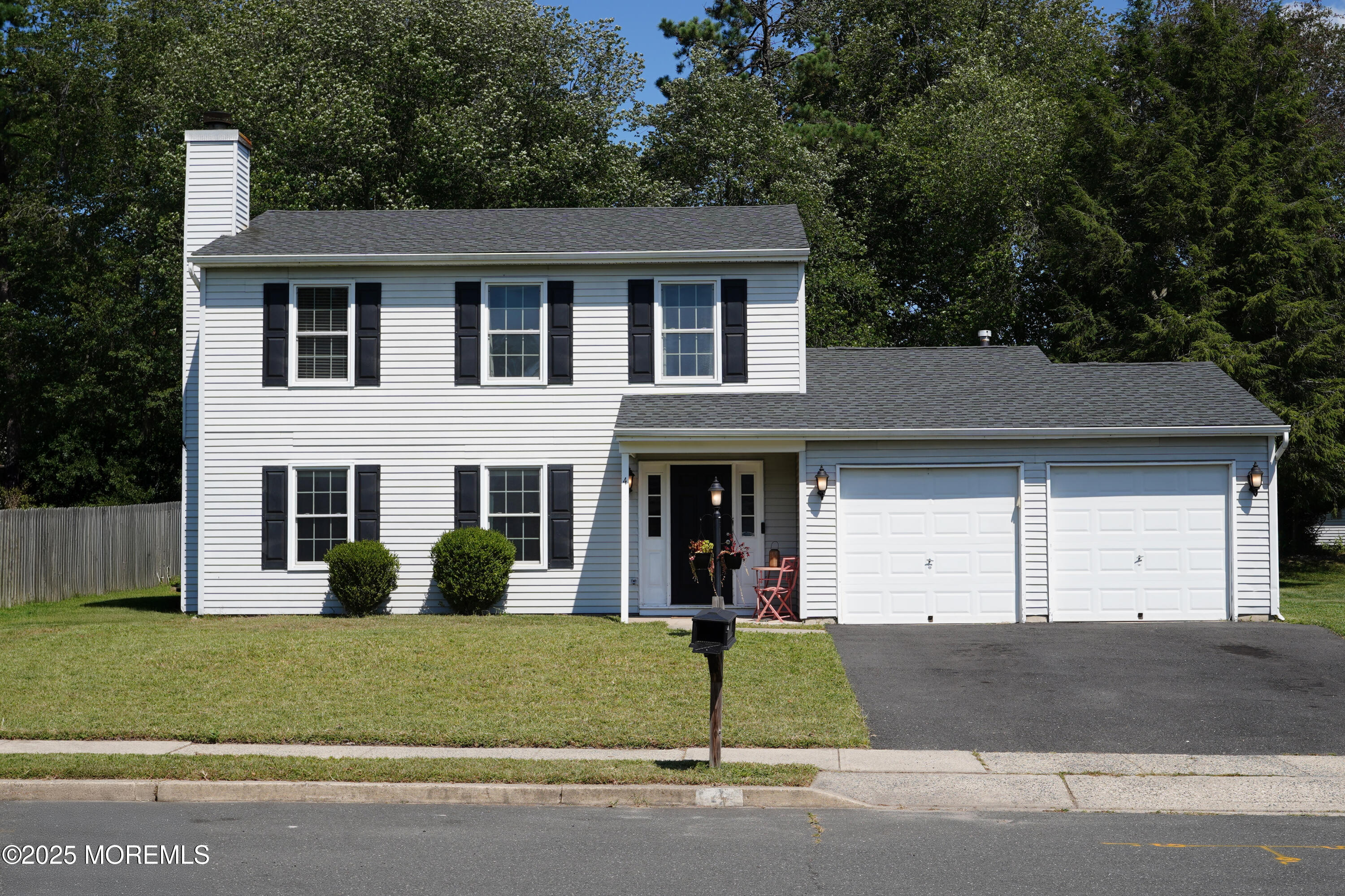 a view of a white house with large windows and a small yard