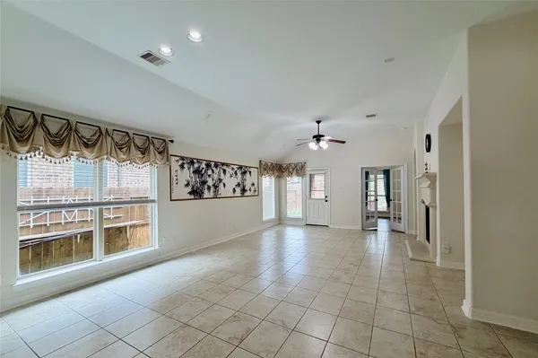 a large white kitchen with a large window and cabinets