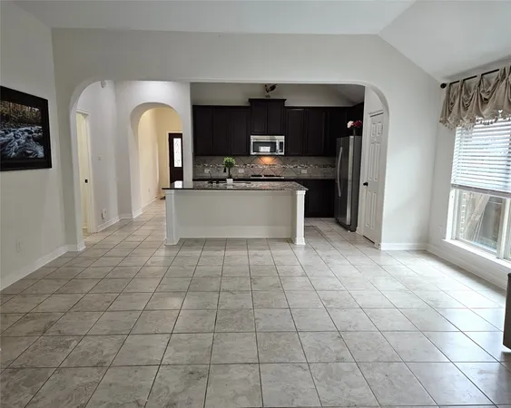 a kitchen with stainless steel appliances granite countertop a refrigerator a stove a sink and a microwave
