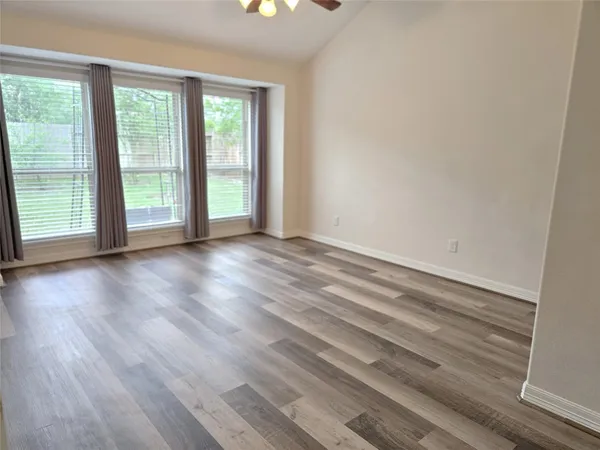 a view of a room with wooden floor and a window