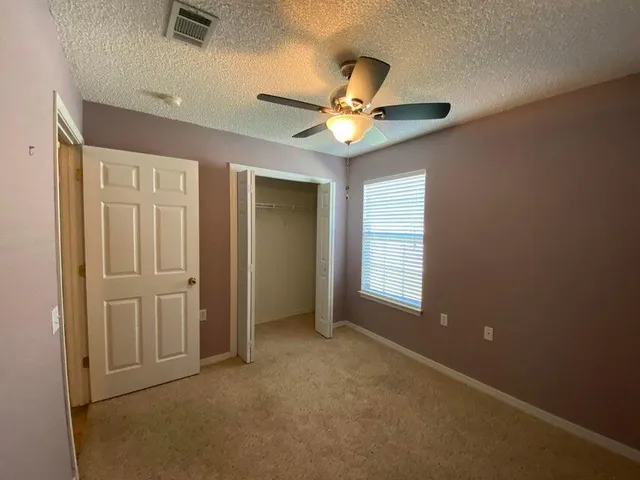 an empty room and chandelier fan