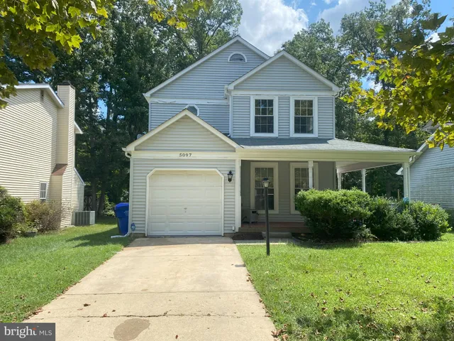 a front view of a house with a garden and plants