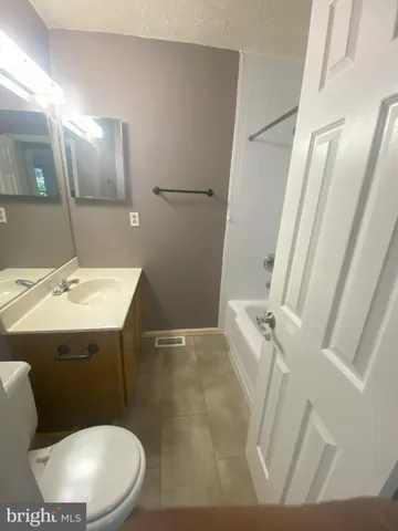 a bathroom with a sink mirror vanity and toilet
