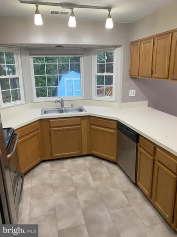 a kitchen with a sink window and cabinets