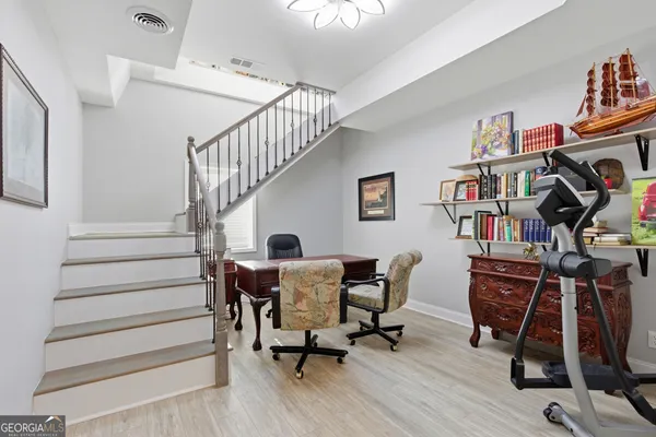 a view of a workspace with wooden floor and stairs