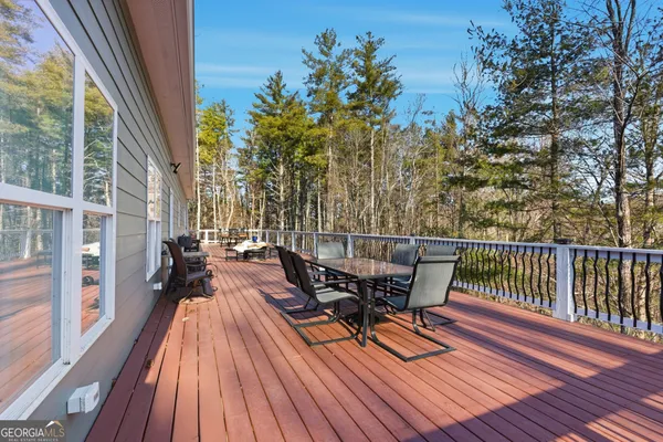 a balcony with wooden floor table and chairs