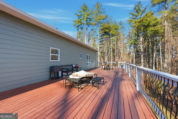 a view of a roof deck with table and chairs and wooden floor
