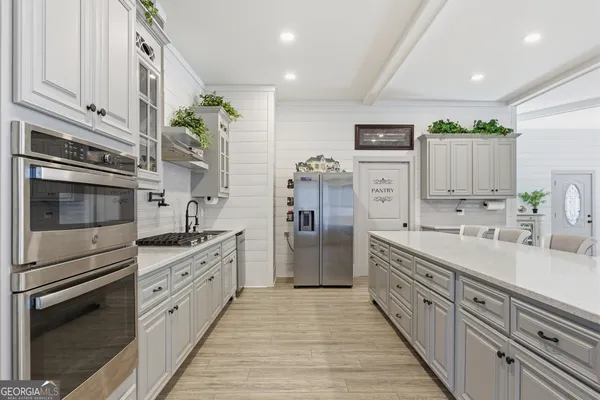 a kitchen with cabinets stainless steel appliances and wooden floor