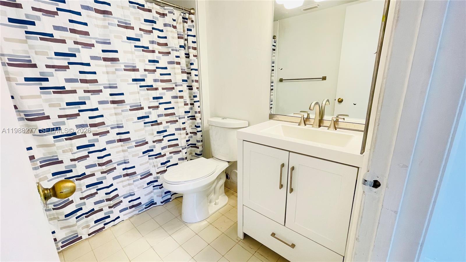 8871 Wiles Road, Unit 105 Coral Springs, FL 33067 - Photo 15 of 43 a bathroom with a sink toilet and mirror
