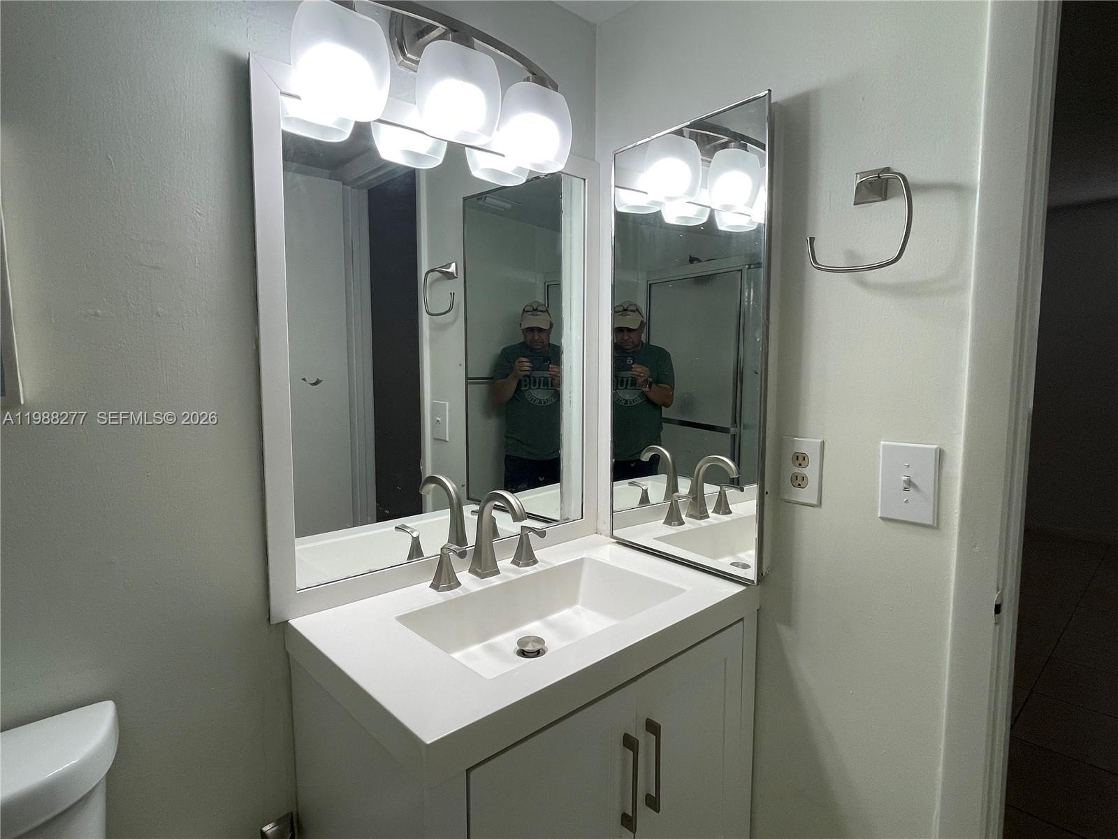 8871 Wiles Road, Unit 105 Coral Springs, FL 33067 - Photo 16 of 43 a bathroom with a sink and a mirror