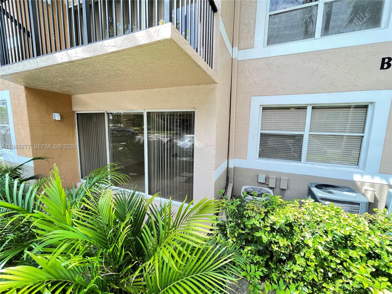 8871 Wiles Road, Unit 105 Coral Springs, FL 33067 - Photo 20 of 43 a front view of a house with a garden
