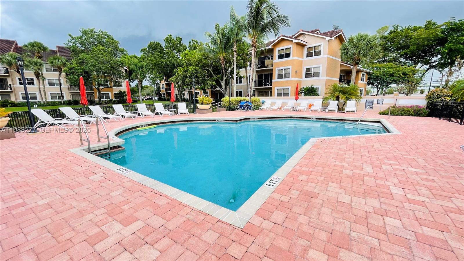 8871 Wiles Road, Unit 105 Coral Springs, FL 33067 - Photo 29 of 43 a view of swimming pool with outdoor seating and plants