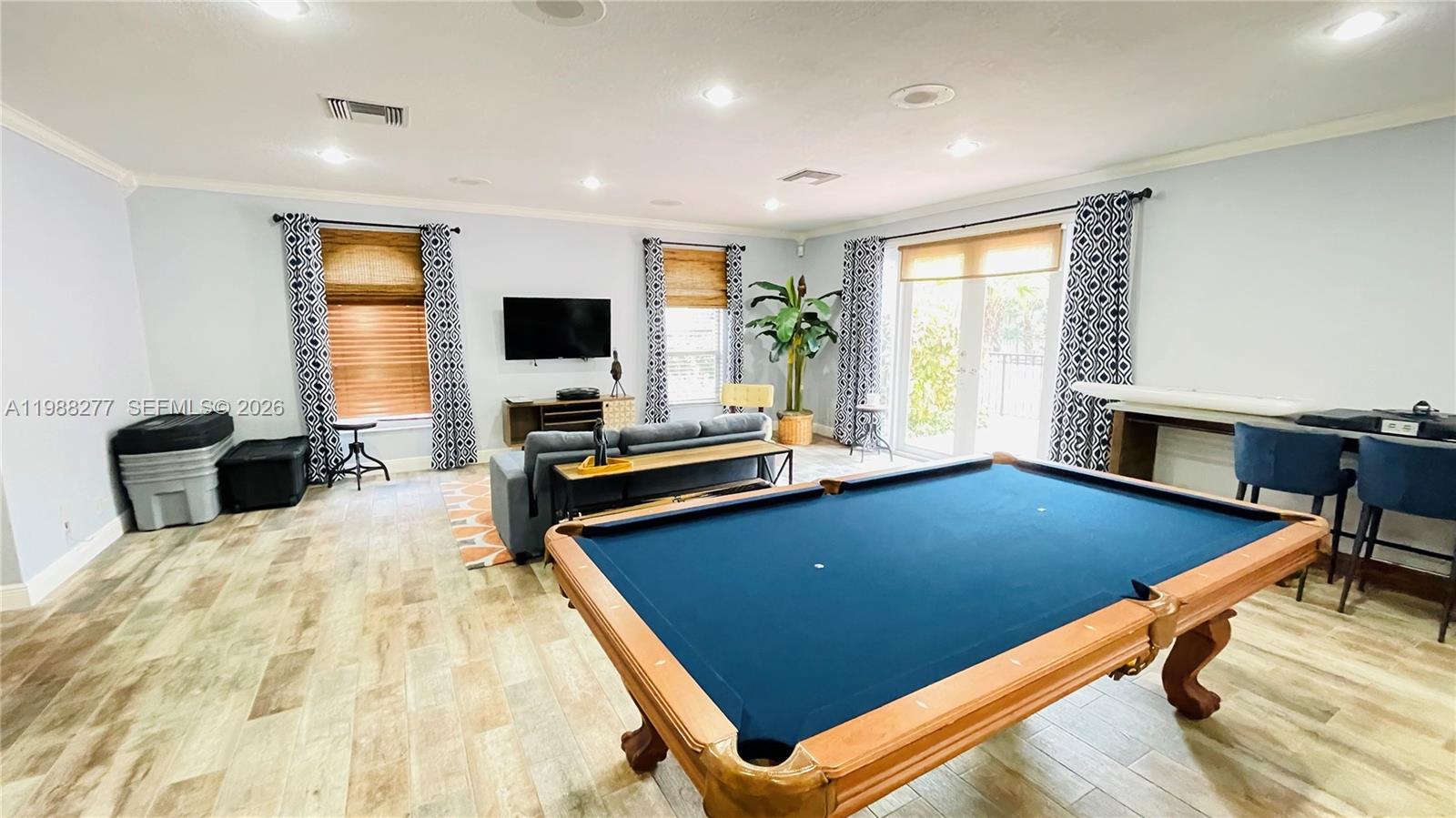 8871 Wiles Road, Unit 105 Coral Springs, FL 33067 - Photo 32 of 43 a living room with dining table furniture and a flat screen tv