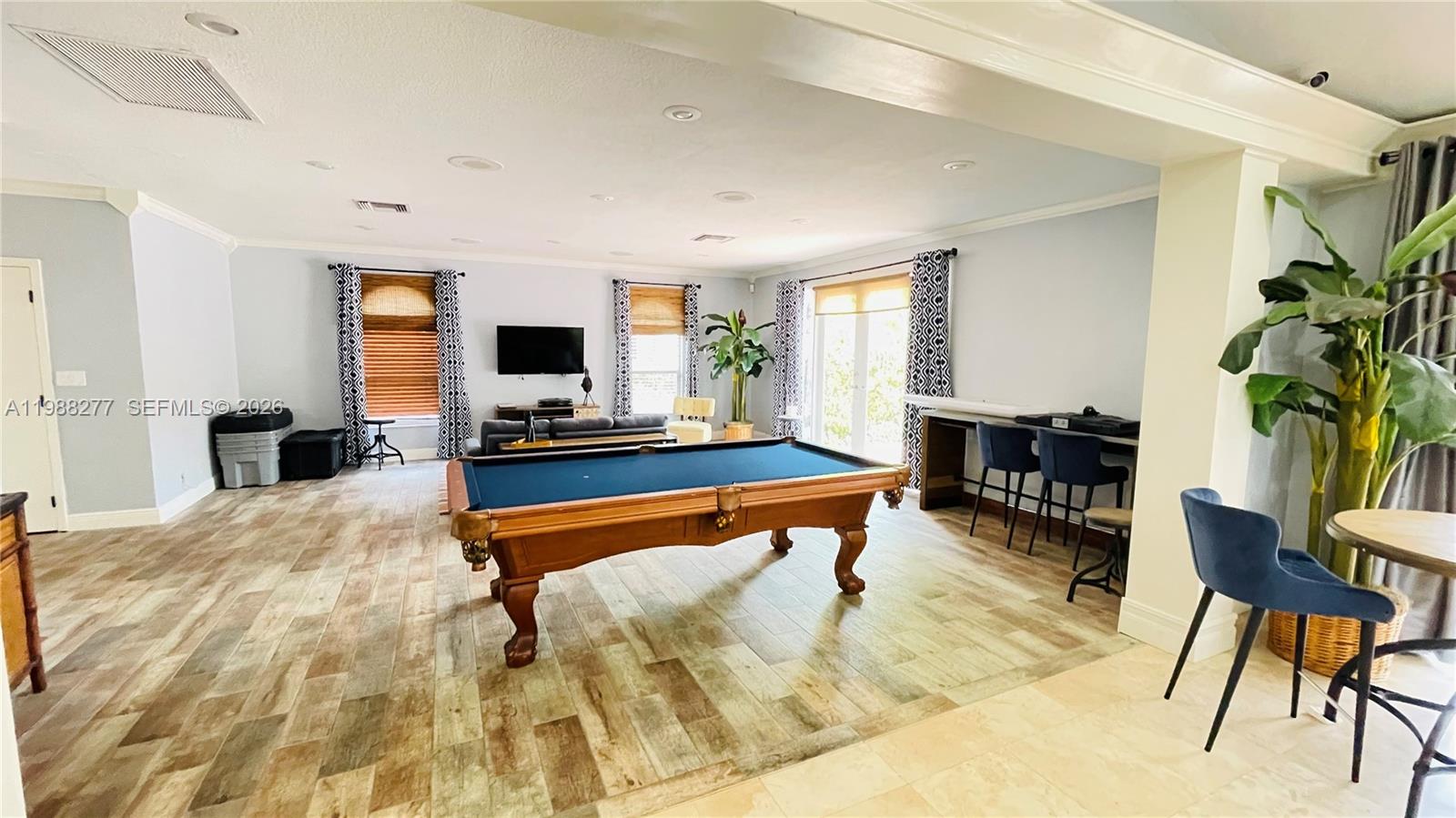 8871 Wiles Road, Unit 105 Coral Springs, FL 33067 - Photo 33 of 43 a living room with furniture and a flat screen tv