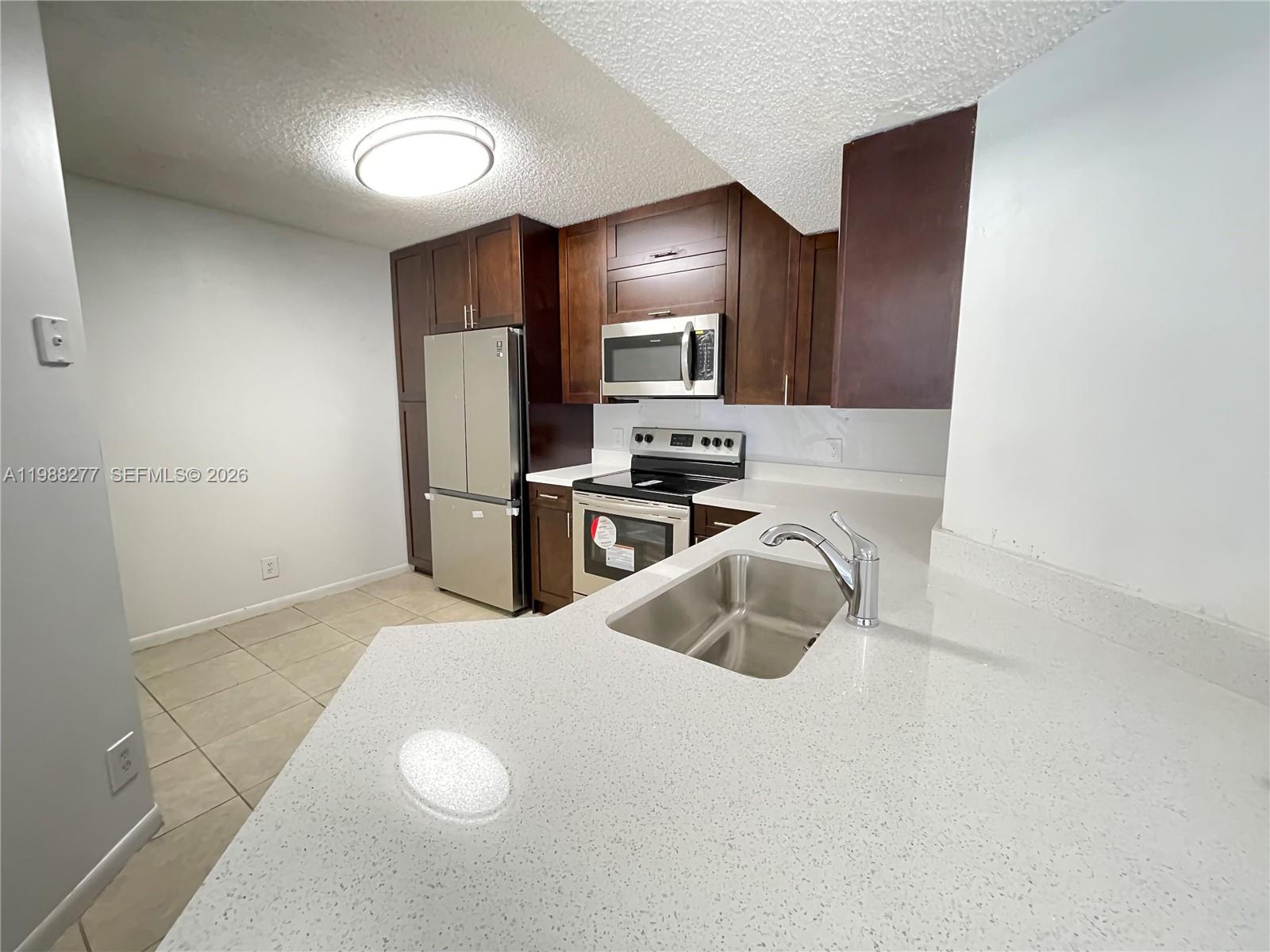 8871 Wiles Road, Unit 105 Coral Springs, FL 33067 - Photo 6 of 43 a kitchen with a refrigerator sink and stove
