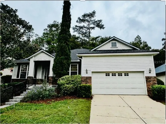 a front view of a house with a yard and potted plants