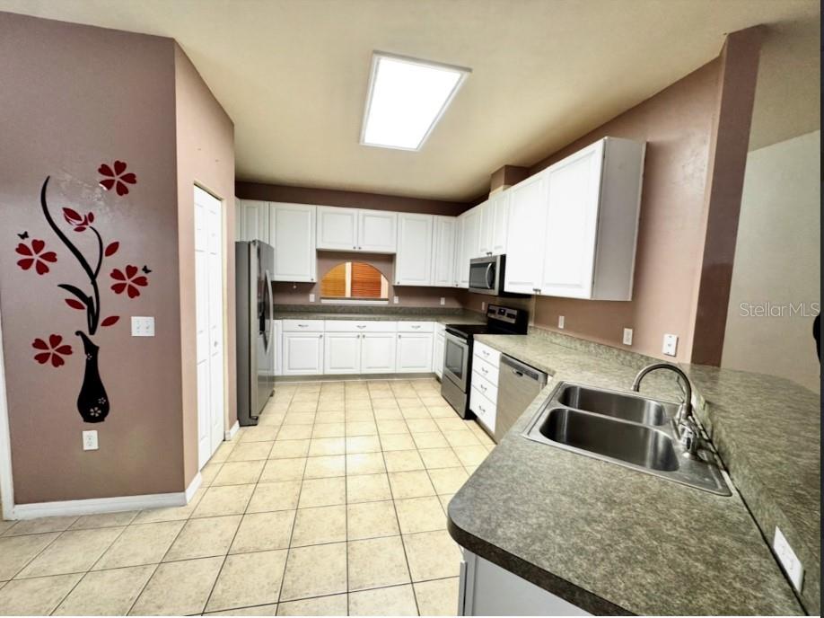 2074 Northwest 101st Street Gainesville, FL 32606 - Photo 6 of 16 a kitchen with stainless steel appliances granite countertop a sink refrigerator and microwave