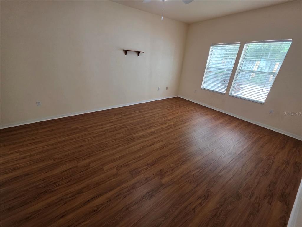 2074 Northwest 101st Street Gainesville, FL 32606 - Photo 8 of 16 an empty room with wooden floor and windows