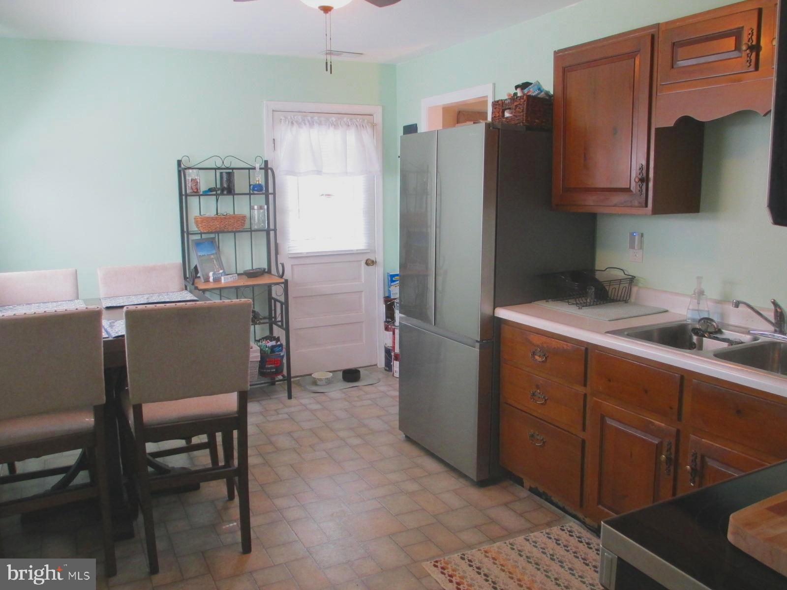 25241 Porters Grove Road Worton, MD 21678 - Photo 10 of 22 a room with cabinets a refrigerator and a chair