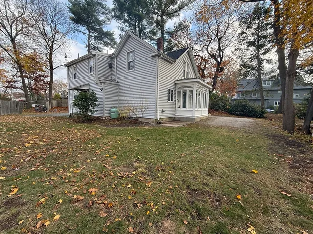 a view of a yard in front of a house with large trees